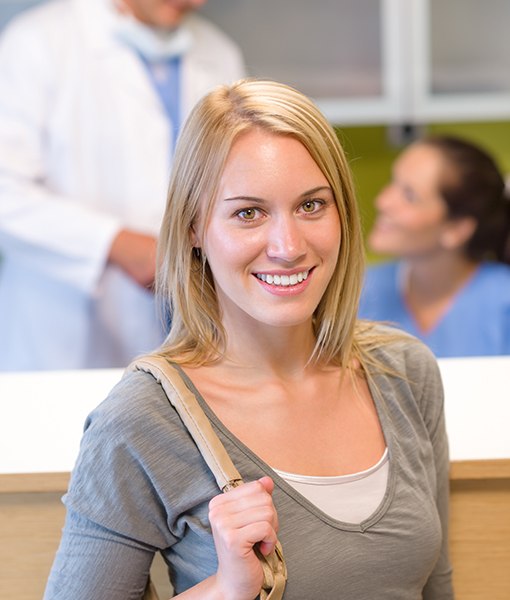 Smiling woman checking in for dental appointment