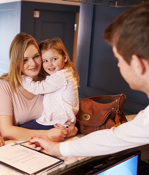 Mother and daughter checking in at dental office