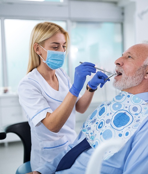 Dentist in Edmonton conducting oral exam on mature male patient