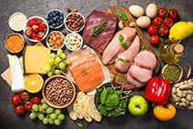 An assortment of healthy foods against a gray background