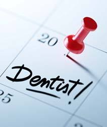 Dental appointment marked on calendar with red thumbtack
