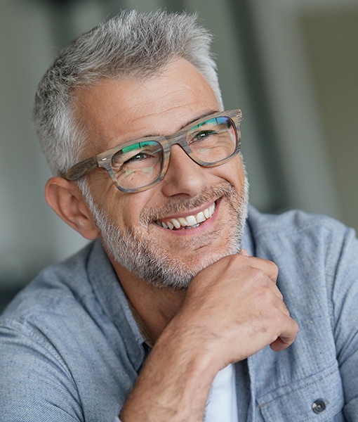 Man smiling after dental implant tooth replacement