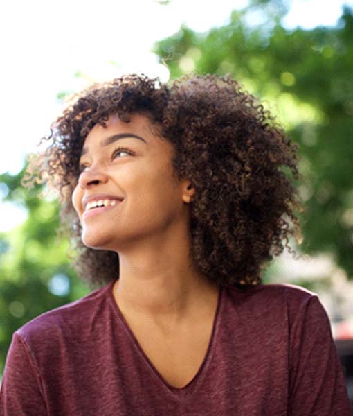 Woman with dental implants in Edmonton, Canada outside smiling