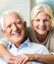 Senior couple with dental implants in Edmonton, Canada on couch