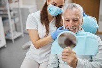 a patient smiling after receiving dental implants