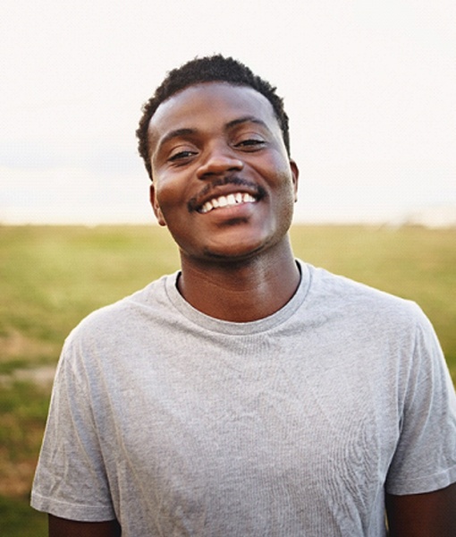 young man smiling after getting root canal in Edmonton