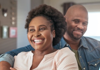 Couple smiling after replacing missing teeth