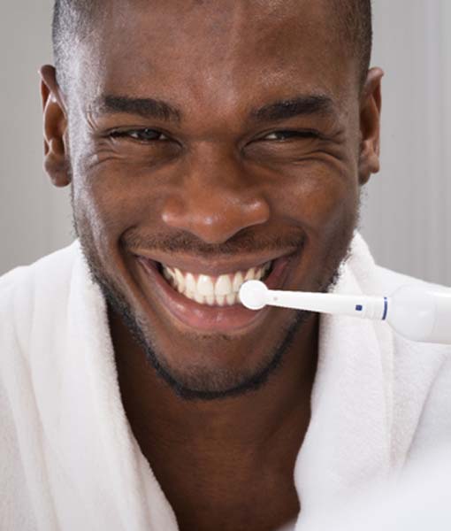 Patient brushing his teeth after teeth whitening in Edmonton 