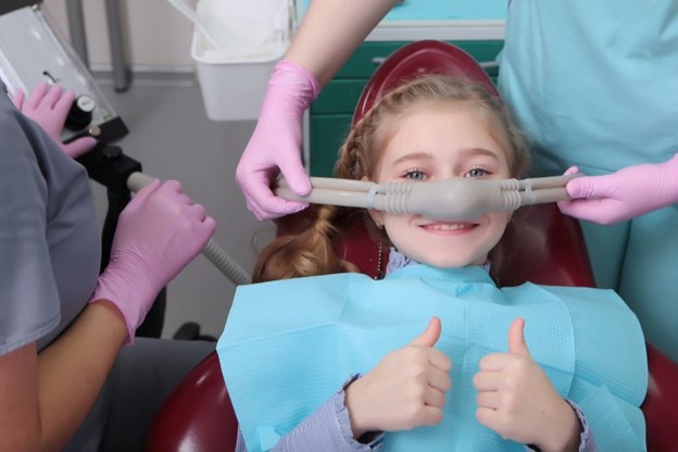 Young girl visiting the dentist and receiving sedation dentistry.