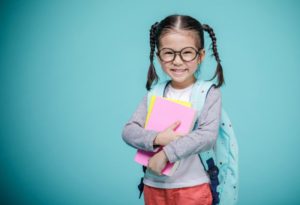 young girl with backpack smiling 